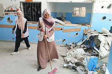 PMRS-Mitarbeiterinnen fegen Schutt weg.