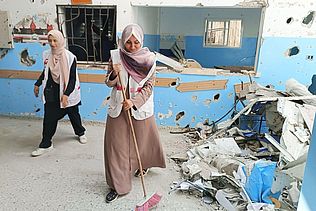 PMRS-Mitarbeiterinnen fegen Schutt weg.