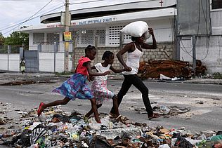 In Port-au-Prince, Haiti flieht eine Frau mit ihren Kindern vor der Gewalt
