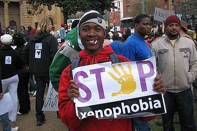 Ein Mann mit einem Schild: Stop Xenophobia