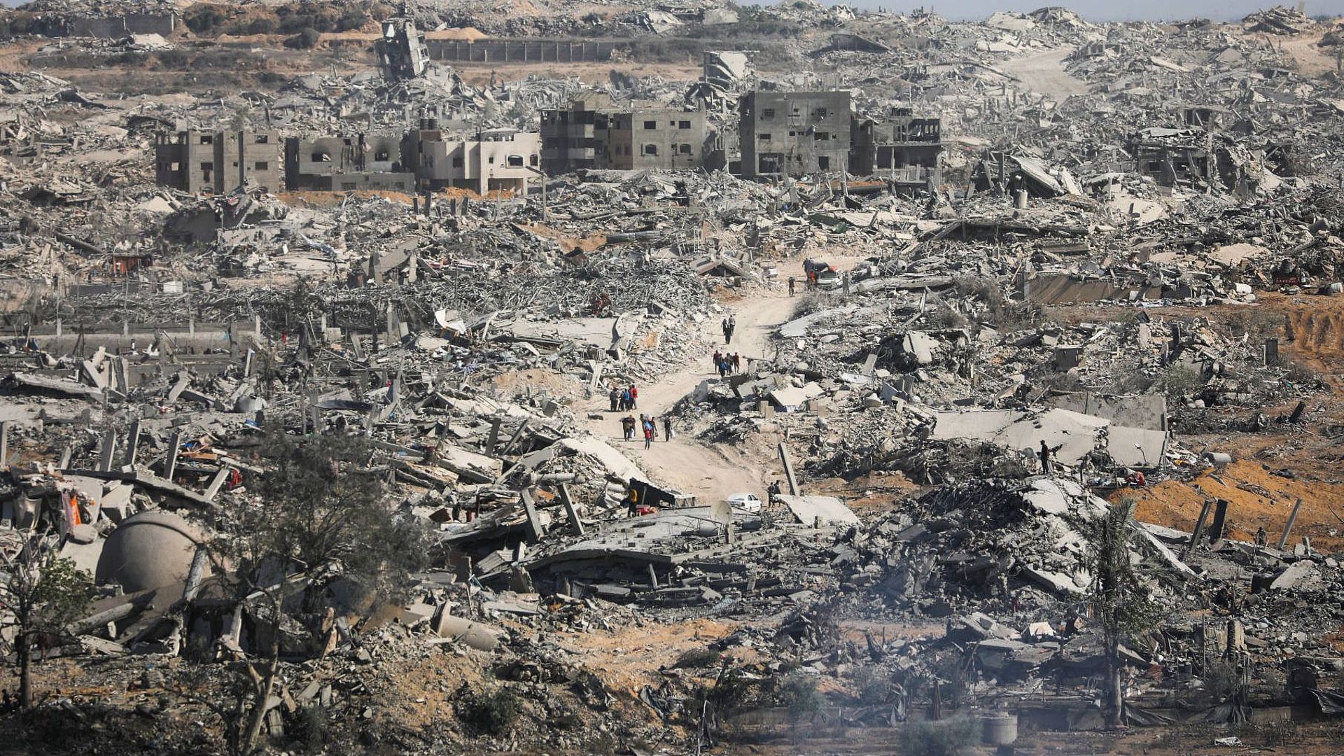 Menschen laufen durch eine Trümmerlandschaft in Gaza.