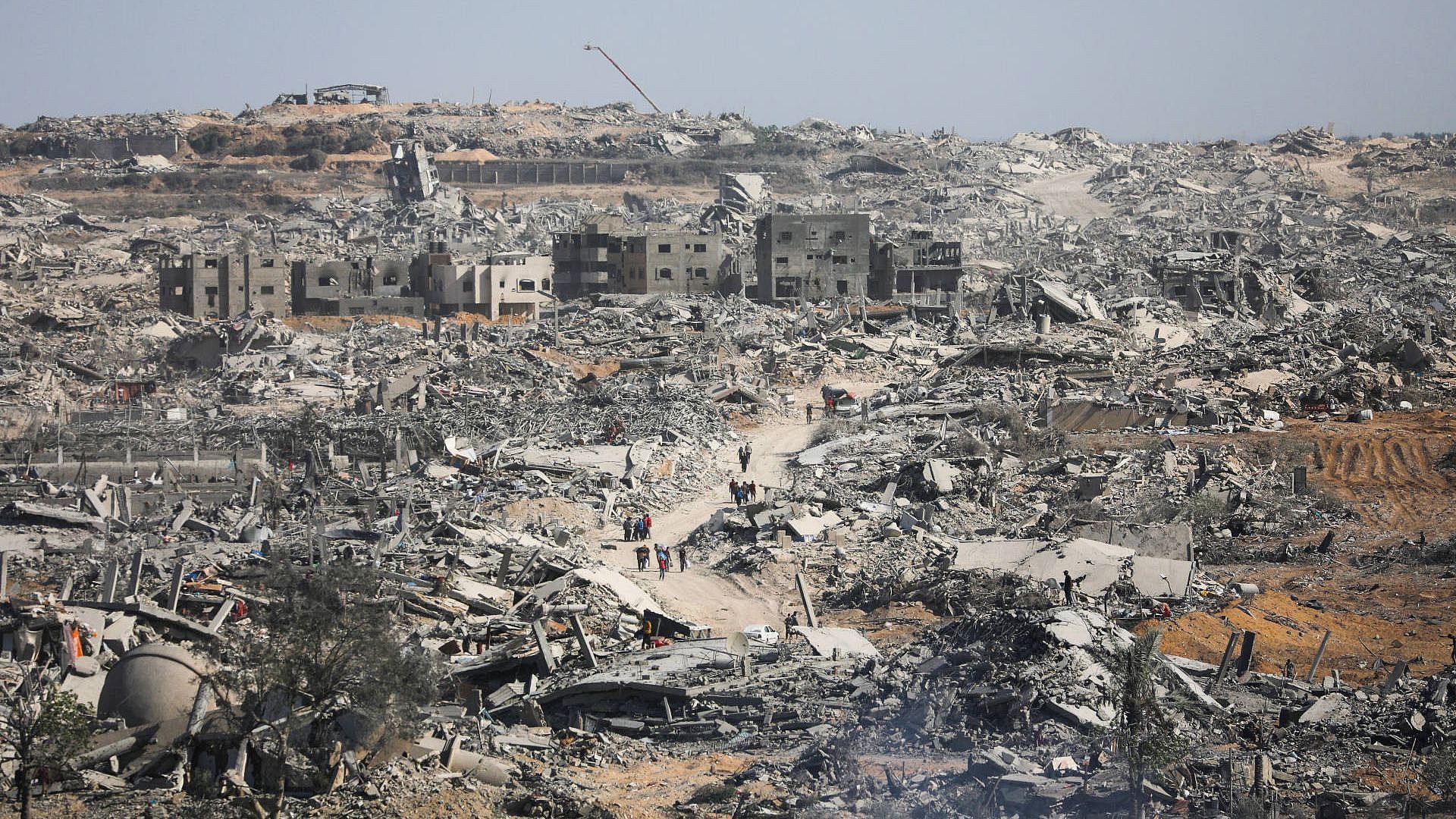 Menschen laufen durch eine Trümmerlandschaft in Gaza.